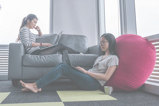 Two women sat down learning on laptops